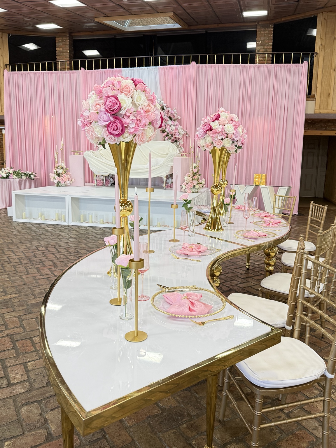 Mesa decorada con arreglos florales rosados